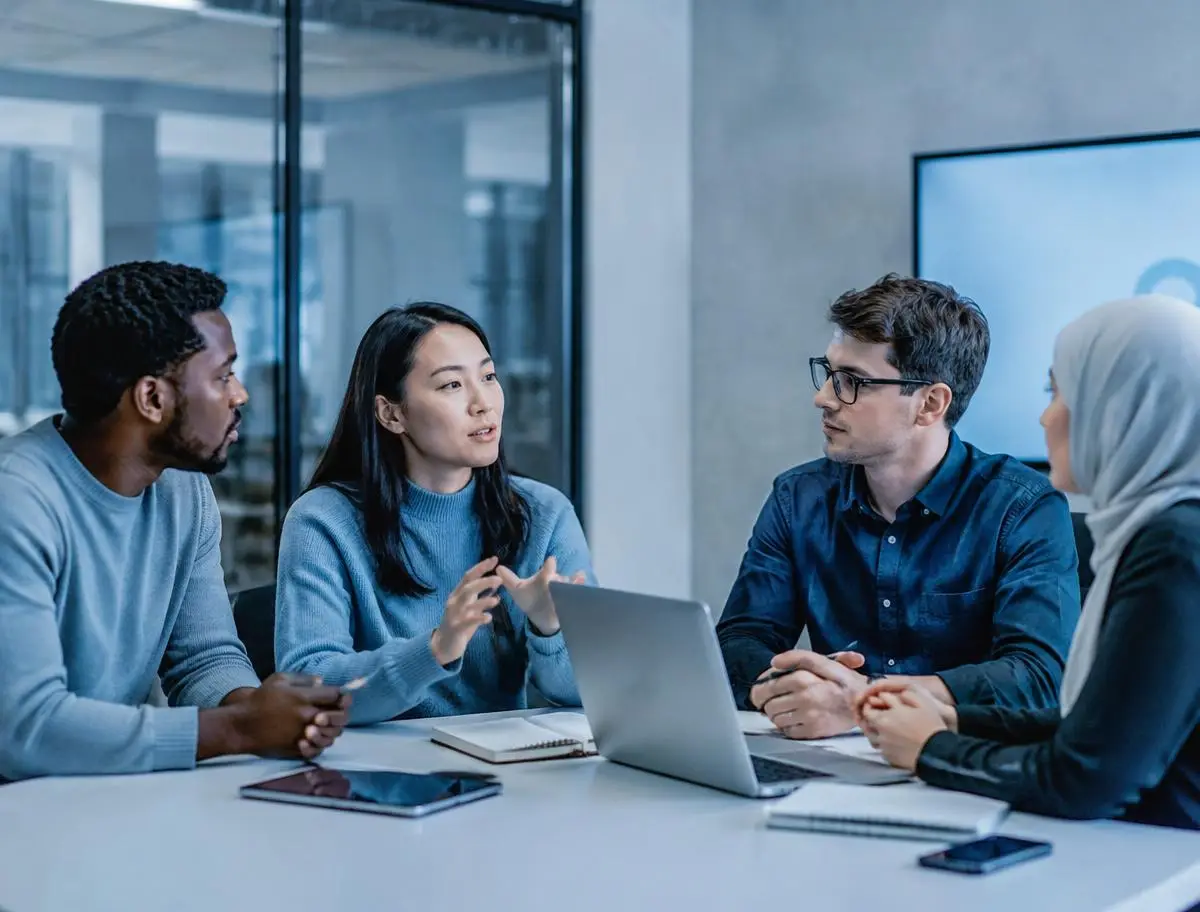 Young leaders discussing plans around a meeting table